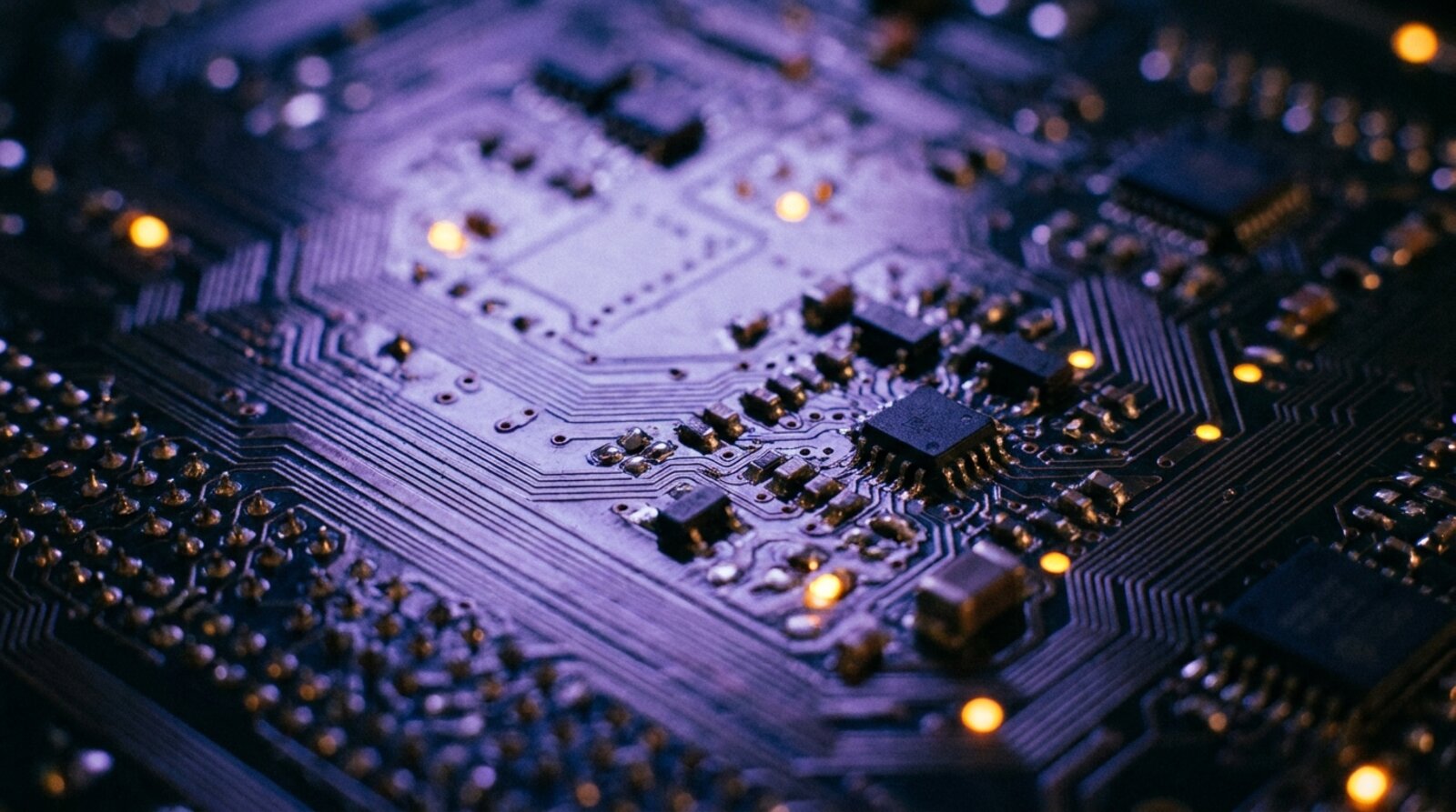 A circuit board lit in violet with a few isolated amber points glowing